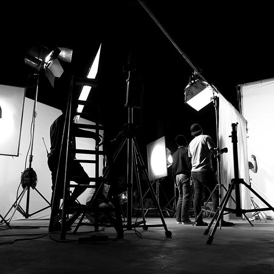 Behind the scenes of TV commercial movie film or video shooting production which crew team and camera man setting up green screen for chroma key technique in big studio.